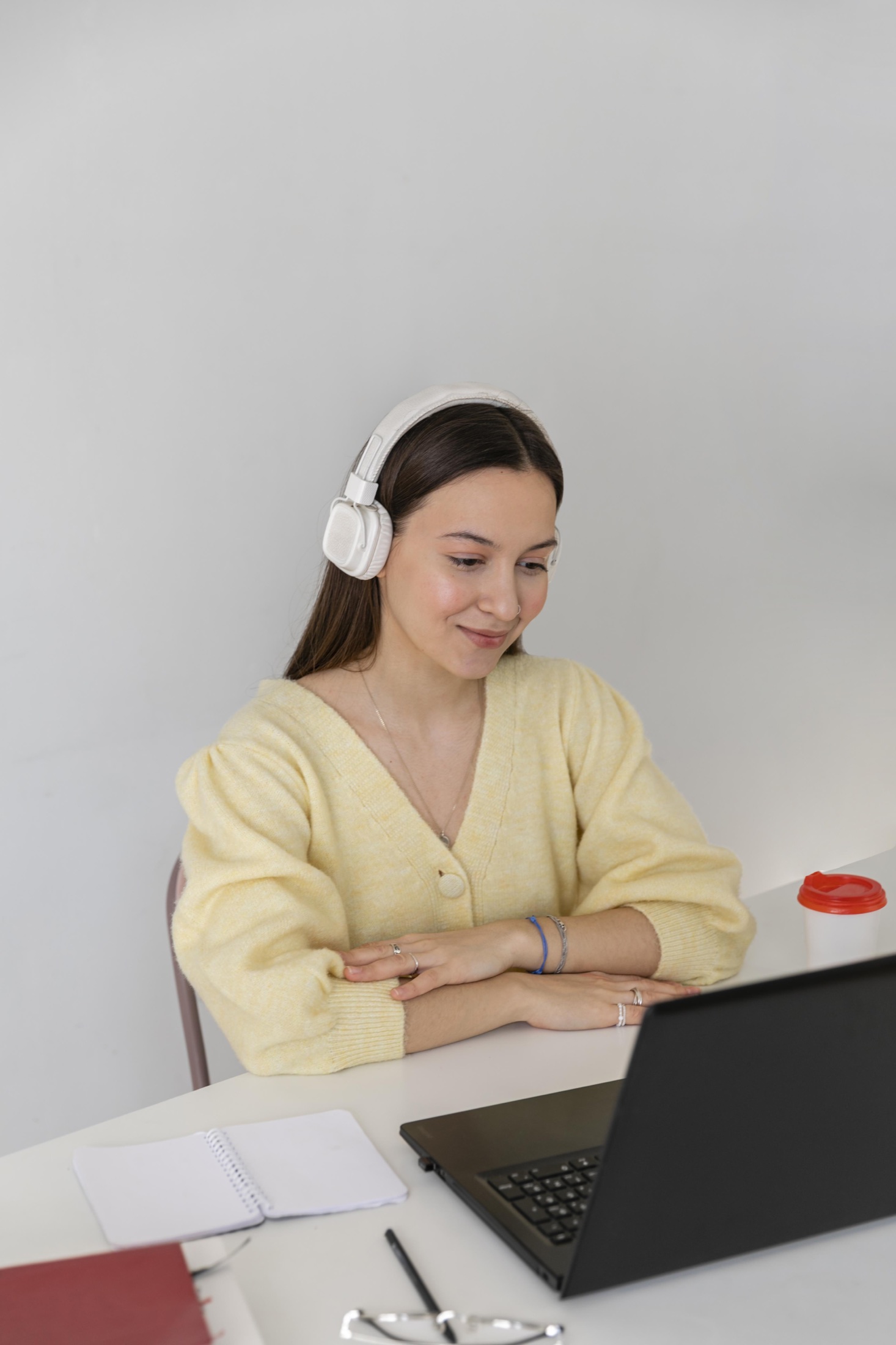 Une femme suit une formation en ligne avec un casque et un ordinateur portable